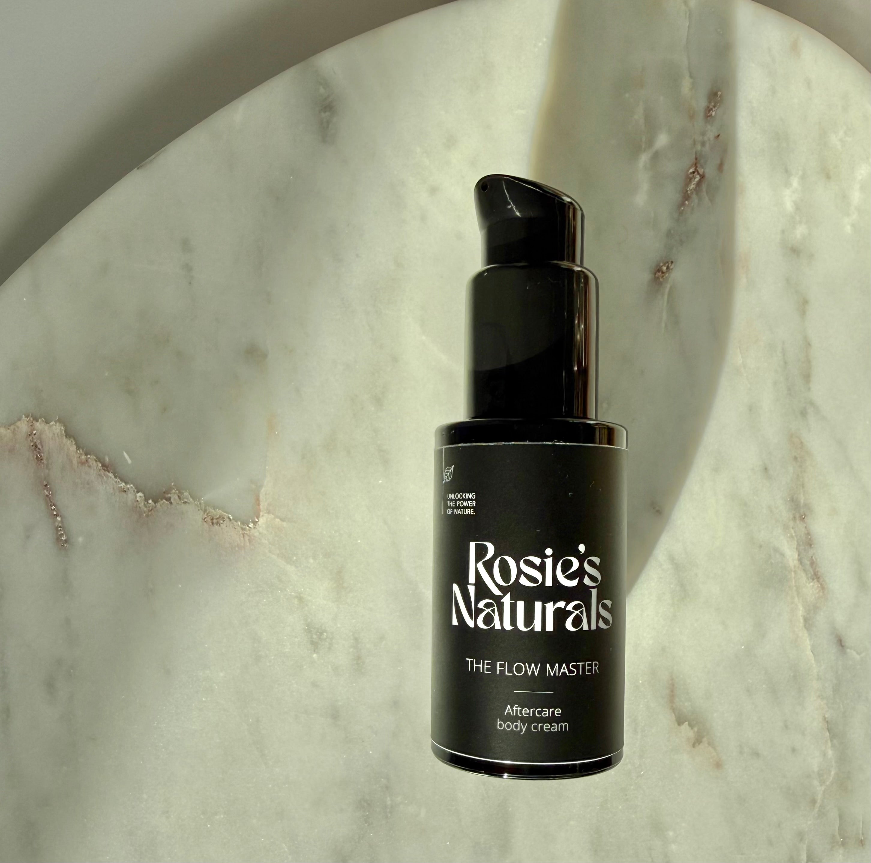 Kleine fles van Rosie's Naturals The Flow Master ligt op een marmeren plaat 