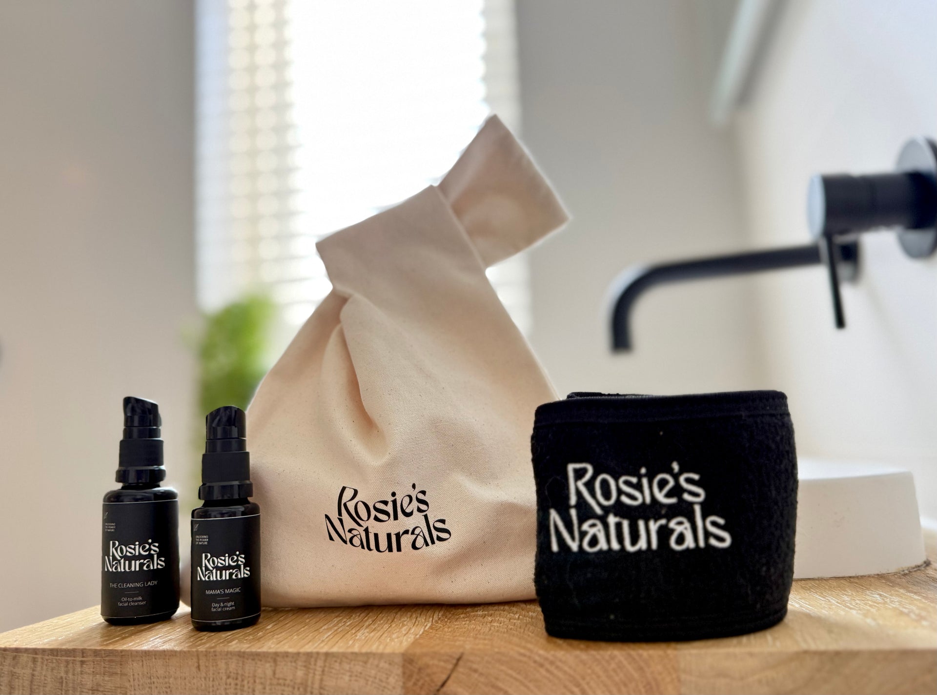 Vooraanzicht van de travel glow bag van Rosie's Naturals met alle producten uitgestald in een badkamer